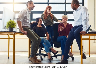 Determined To Succeed Together. Shot Of A Group Of Designers Having A Discussion In An Office.