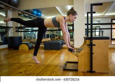 Determined woman exercising on wunda chair in gym - Powered by Shutterstock