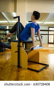 Determined woman exercising on wunda chair in gym