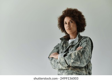 A determined young African American soldier stands proudly, arms crossed, showcasing her military spirit. - Powered by Shutterstock