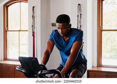 Determined Young Black Man Doing Cardio Workout On Exercise Bike At The Gym