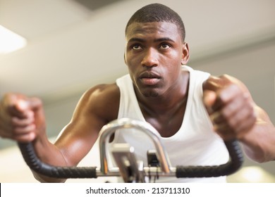 Determined Young Man Working Out On Exercise Bike At The Gym