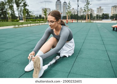 A determined young woman with a prosthetic leg engages in outdoor exercise, showcasing strength and resilience. - Powered by Shutterstock