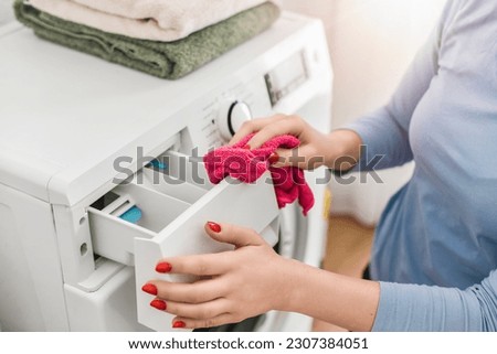 Detial of cleaning  washing machine, Woman using red cloth to clean wash machine.