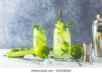 Detox cocktail with mint, cucumber and lime or mojito cocktail in highball glasses on a gray concrete stone surface background. With copy space for your text