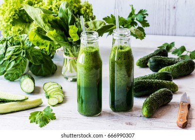 Detox diet. Two small bottles of fresh green smoothies with ingredients on a light wooden background. - Shutterstock ID 666990307