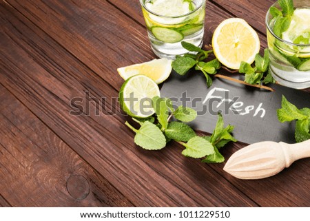 Detox drink with cucumber, lemon and mint on a wooden background. Copy space. Food background