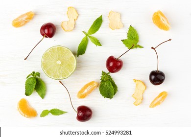 Detox Food & Drink Healthy Lifestyle Concept: Healthy Diet Green & Orange Fruits & Herbs For Mojito. Lime Cherry Orange Mandarin & Mint Herb. Top View White Wooden Background. Free Space Text Layout