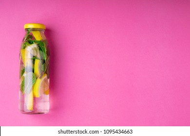 Detox Fruit Infused Water With Citrus Fruits And Mint Leaves On Pink Background. Summer Background With Summer Drink Lemonade. Top View. Copy Space