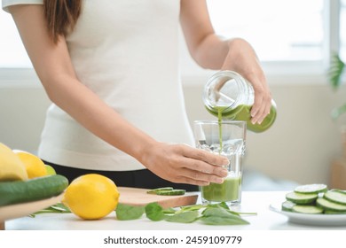Detox juice concept, Hand of woman, girl holding bottle making green vegetable smoothie pouring in glass for diet at home kitchen, drinking healthy meal food for weight loss. Lifestyle vegan nutrition