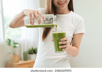 Detox juice concept, Hand of woman, girl holding bottle making green vegetable smoothie pouring in glass for diet at home kitchen, drinking healthy meal food for weight loss. Lifestyle vegan nutrition - Powered by Shutterstock