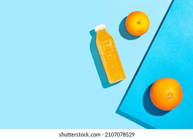 Detox Juice In A Plastic Bottle, Oranges On A Blue Background. Top View, Flat Lay