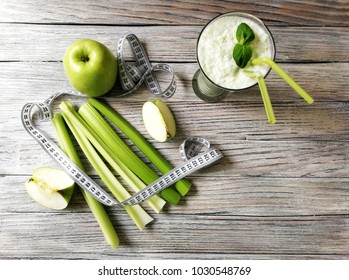 detox smoothie, celery with green Apple  with measuring tape on white aged wooden background