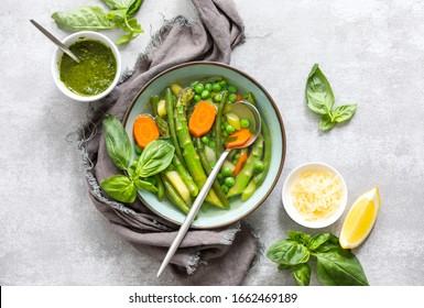 Detox Vegetable Spring Soup, Green Minestrone Inspired Recipe, Overhead View On Ready To Eat Served With Pesto And Parmesan Dish