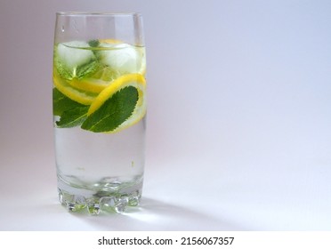 Detox water with lemon slices and fresh mint leaves in a glass. Isolated on white background. Ð¡opy space.