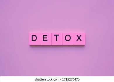 Detox word wooden cubes on pink background