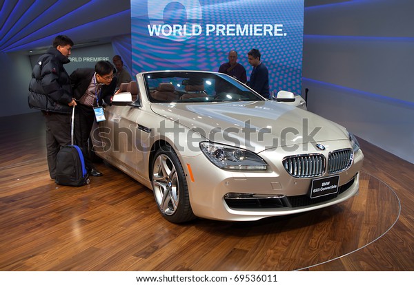 DETROIT - JANUARY 11: Members of the press look\
at the new BMW 650i convertible on display at the 2011 North\
American International Auto Show Press Preview on January 11, 2011\
in Detroit, Michigan.
