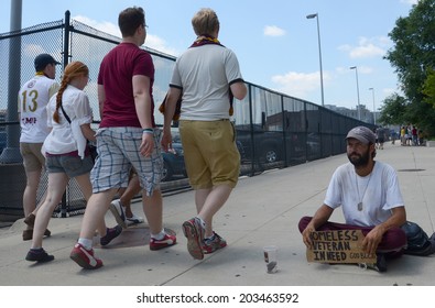 DETROIT, MI - JULY 6: People walking past homeless veteran begging for money in Detroit, MI on July 6, 2014