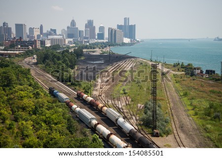 Detroit Michigan Railroad - The railroad and shipping docks along the Detroit River with downtown Detroit, Michigan in the background on a hazy summer day. 