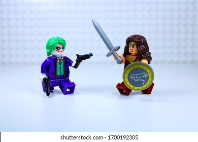 DETROIT, USA - APRIL 11, 2020: Joker attacks Wonder woman. Lego mini-figures. Joker points his gun at Wonder woman. Wonder woman attacks Joker with her sword and shield.