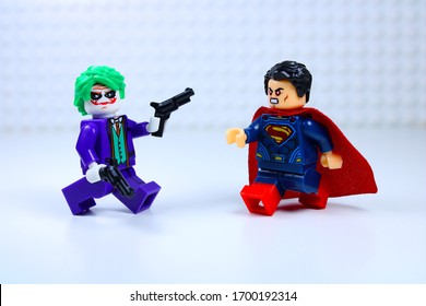 DETROIT, USA - APRIL 11, 2020: Joker points his gun at Super man. Lego  Mini figures. Joker attacks Superman.