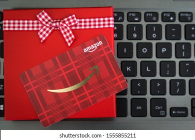 Detroit, USA - Nov 11, 2019 : Red color Amazon gift card in red box with reindeer ornament on laptop keyboard as a Christmas present