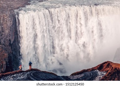 Dettifoss powerful Waterfall of Iceland view close up. Wonderful nature landscape.  photographers stands at the edge of trail in front of waterfall. Iconic location for landscape photographers.