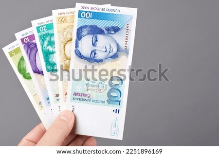 Deutsche money - Mark in the hand on a gray background	