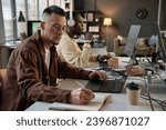 Dev team lead reviewing code and taking notes in planner