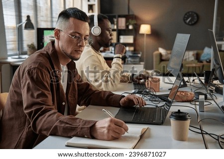 Dev team lead reviewing code and taking notes in planner