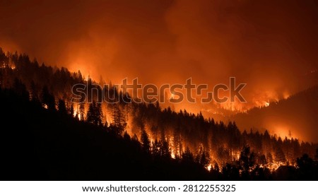 A devastating forest fire engulfs a hillside at night, with bright orange flames illuminating the dark sky and thick smoke billowing upwards.