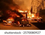 A devastating wildfire fueled by powerful winds engulfs vehicles and a house in flames, highlighting the destruction in Los Angeles.