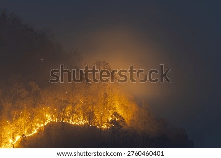 Devastating wildfire smoke spreading across forest mountain at night causing alarming environmental disaster and severe air pollution hazard in northern region destroying natural habitat