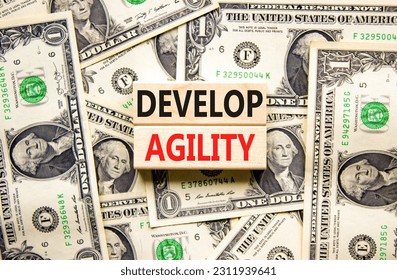 Develop agility symbol. Concept words Develop agility on wooden blocks on a beautiful background from dollar bills. Business, support and develop agility concept. Copy space. - Shutterstock ID 2311939641