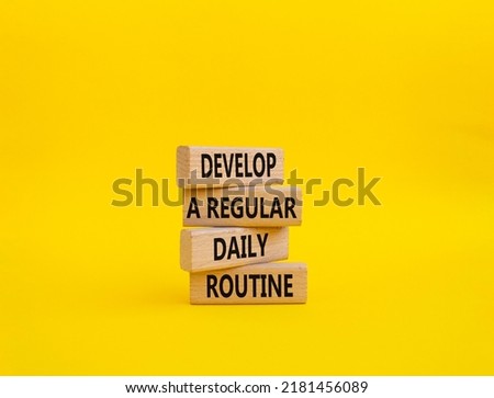 Develop a regular daily routine symbol. Concept words Develop a regular daily routine on wooden blocks. Beautiful yellow background. Business and Develop a regular daily routineconcept. Copy space.