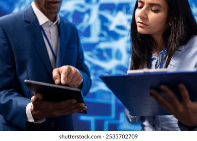 Developer and colleague analyzing complex AI brain models on tablet. IT specialist and coworker using machine learning software on device to develop artificial intelligence technology