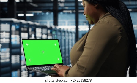 Developer in data center using green screen laptop to upgrade systems for increased stability. IT expert in server farm configuring hardware with mockup notebook for optimum performance, camera B
