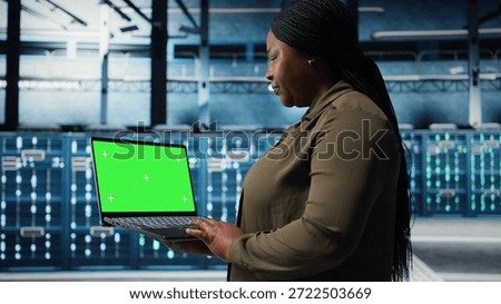 Developer in data center using green screen laptop to upgrade systems for increased stability. IT expert in server farm configuring hardware with mockup notebook for optimum performance, camera A
