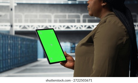 Developer in data center using isolated screen tablet to upgrade systems for increased stability. IT expert in server farm configuring hardware with chroma key device for optimum performance, camera B