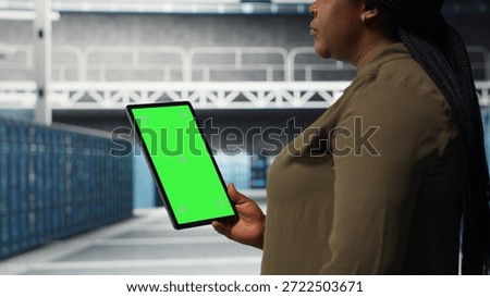 Developer in data center using isolated screen tablet to upgrade systems for increased stability. IT expert in server farm configuring hardware with chroma key device for optimum performance, camera B
