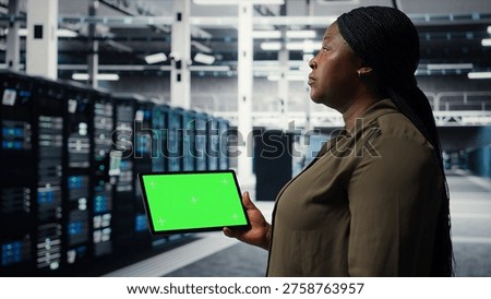 Developer in data center using isolated screen tablet to upgrade systems for increased stability. IT expert in server farm configuring hardware with chroma key device for optimum performance, camera A