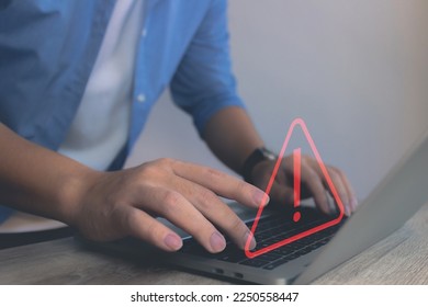 Developer man hand using laptop show triangle caution warning malware icon screen detected in computer.Scam Virus Spyware Malware Antivirus Concept, Cybersecurity, cyber crime,hack password.