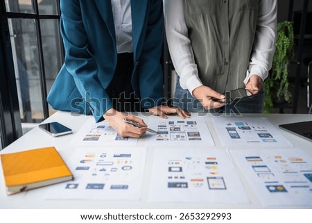 Developer team brainstorming user interface and experience designs for mobile application ux ui graphic prototype 