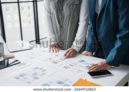 Developer team brainstorming user interface and experience designs for mobile application ux ui graphic prototype 