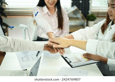 Developer team stacking hands together celebrating completion of project, motivating and team building
