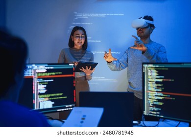 developer uses a VR headset to interact with projected interface designs, while colleagues discuss and code on screens, highlighting the integration of virtual reality and UIUX design