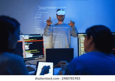developer uses a VR headset to interact with projected interface designs, while colleagues discuss and code on screens, highlighting the integration of virtual reality and UI UX design - Powered by Shutterstock