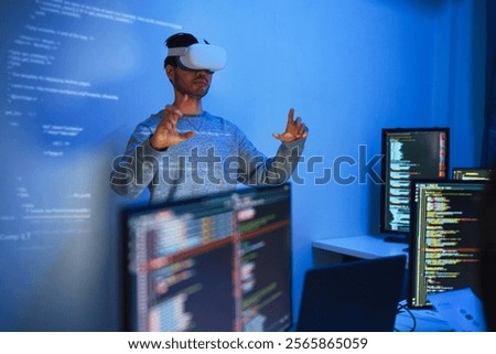 developer uses a VR headset to interact with projected interface designs, while colleagues discuss and code on screens, highlighting the integration of virtual reality and UIUX design in software