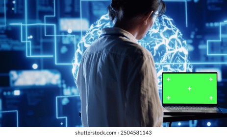 Developer using green screen laptop to implement artificial intelligence parallel processing, breaking up complex computational tasks enabling AI systems to process more input data faster