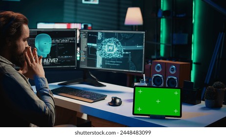 Developer using green screen tablet updating artificial intelligence machine learning algorithm, writing binary code scripts. IT expert programming on mockup device to upgrade AI brain, camera B